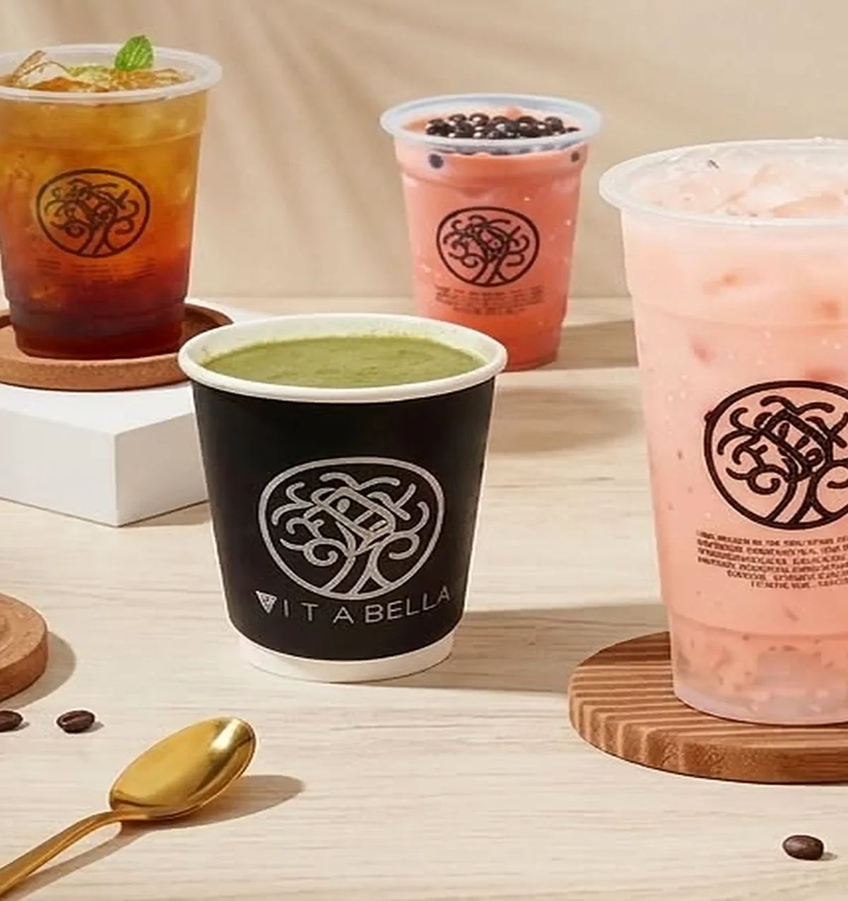 Vita Bella drinks lined up — iced coffee, milk tea with pearls and a matcha cup